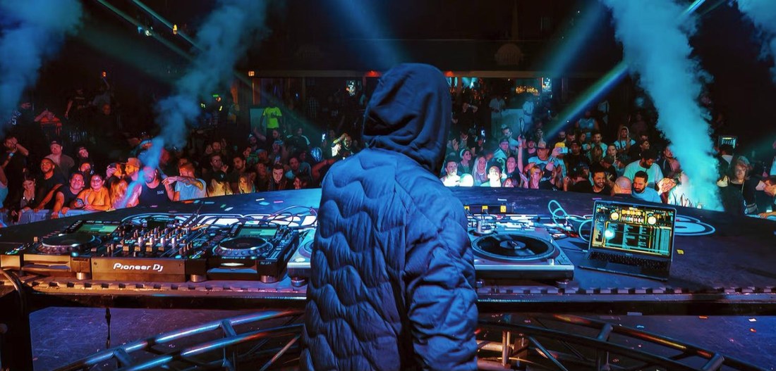 Behind the booth: the DJ from the back, facing the crowd